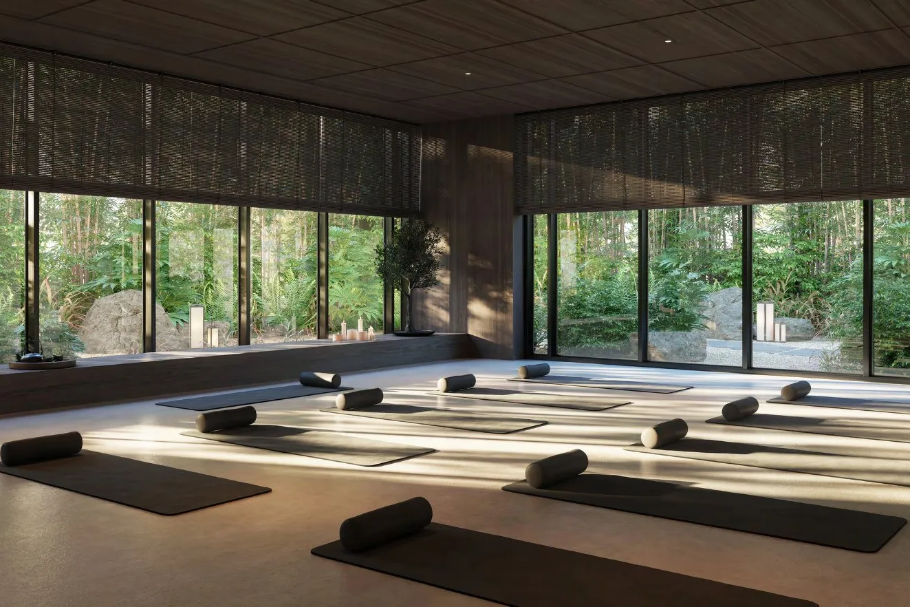 Yoga studio with mats laid out and floor-to-ceiling windows onto bamboo garden